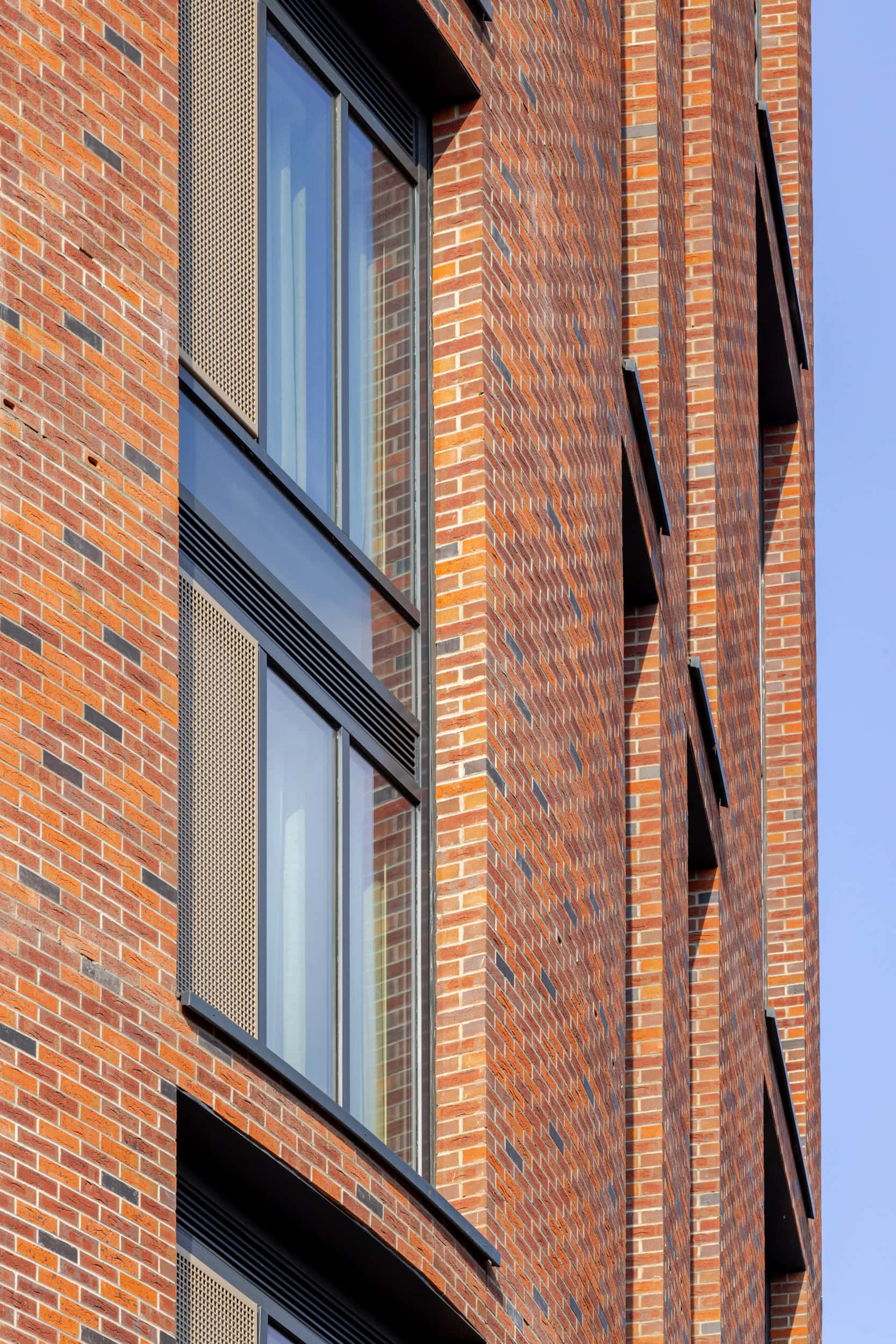 Close-up of a brick building with large windows and modern design elements.