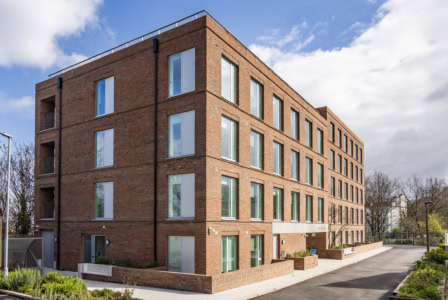 Contemporary brick apartment building at Leon House, The Heights with large windows and landscaped.
