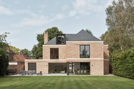 Contemporary brick house with large glass doors and a spacious lawn in Cobham.