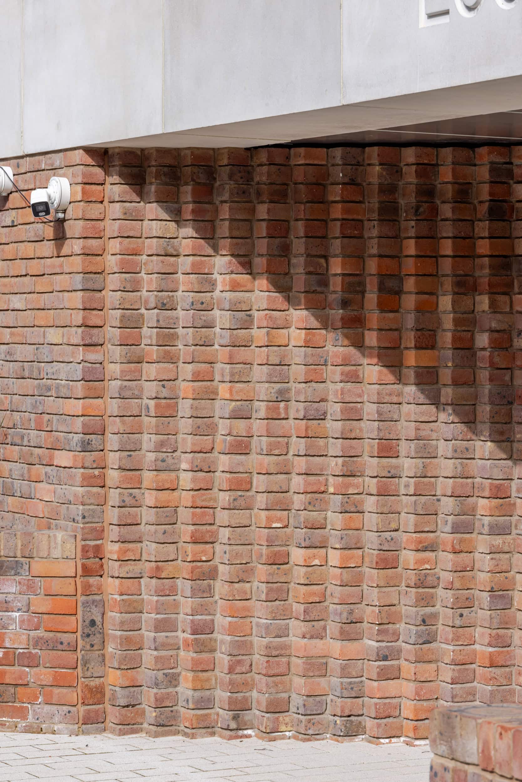 Brick wall exterior with security camera at The Heights.