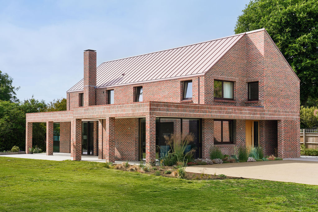 Contemporary brick house with large windows and landscaped garden.
